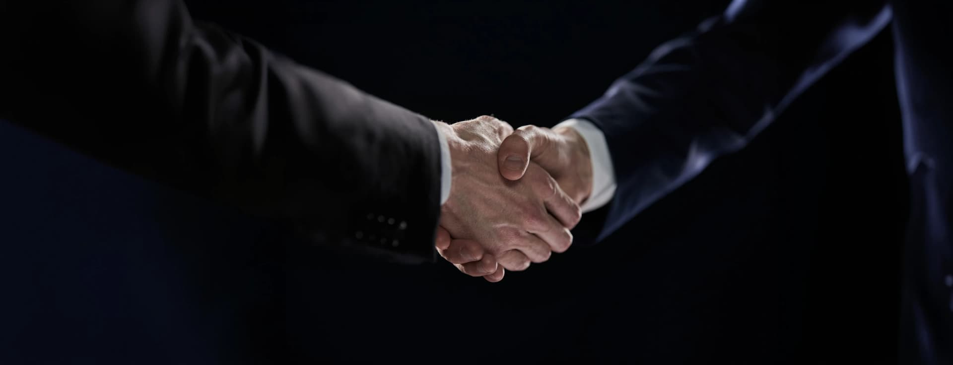 Professional handshake representing PCU partnerships and MoUs