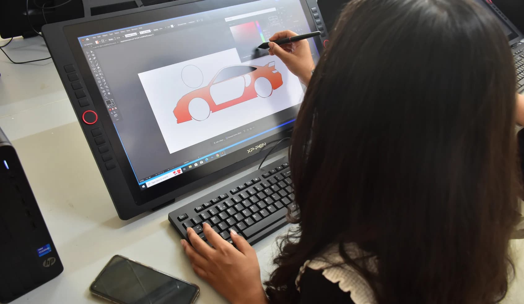 Animation & Game Design student illustrating a vehicle concept on a drawing tablet